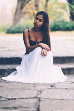 Uzun beyaz elbiseli güzel kız parkta hayal 