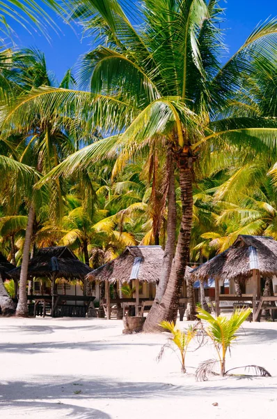 Paisaje de paraíso isla tropical con palmeras, cabañas y playa de arena blanca —  Fotos de Stock