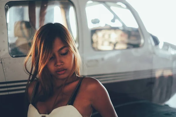 Hermoso retrato femenino en el hangar del avión, con aviones modernos — Foto de Stock