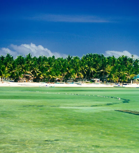 Пляж с белым песком, зелеными пальмами и припаркованными рыбацкими лодками в песке. Экзотический островной рай — стоковое фото
