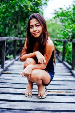 Genç güzel kız portre mangrov ormanın içinde ahşap köprü