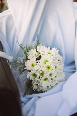 Taze bahar çiçekleri gelen düğün buketi. Beyaz kumaş üzerine beyaz dahlia çiçekli gelin buketi