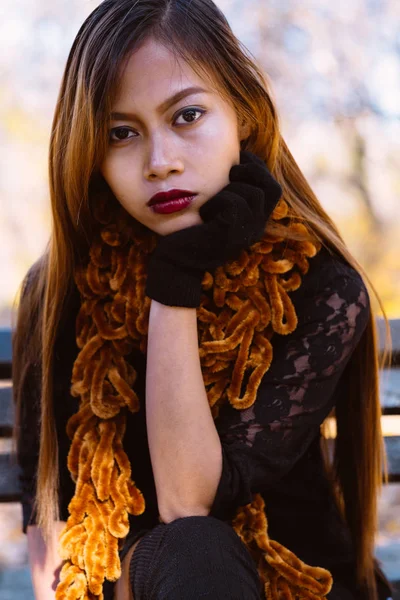 Retrato de jovem bela mulher sentada no banco em elegante roupa quente no dia ensolarado de outono no parque. Estilo de vida casual na cidade — Fotografia de Stock