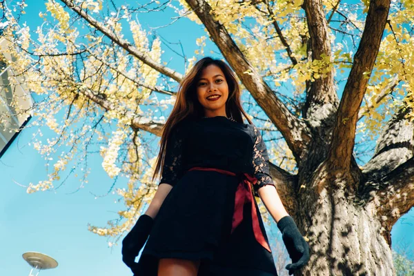 Jovem feliz no parque no dia ensolarado do outono, sorrindo. Menina bonita alegre em preto vestido retro outono estilo de moda — Fotografia de Stock