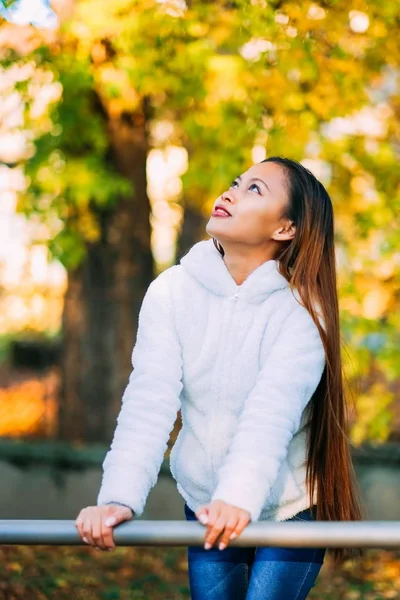 Sonbahar sezonu ile renkli sonbahar arka plan açık beyaz yün ceketli mutlu bir genç güzel kadın portresi