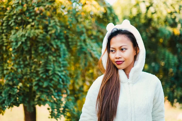 Jovem mulher bonita feliz no parque de outono no dia ensolarado, Jovem mulher de casaco branco durante o pôr do sol no parque — Fotografia de Stock