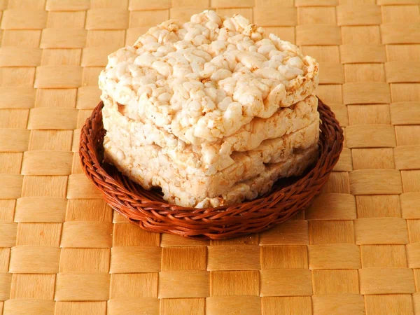 Arroz, pan de trigo en la canasta sobre fondo marrón — Foto de Stock