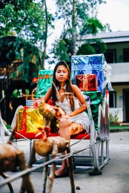 Tropikal Noel kavramı. Noel Baba kızak parlak renkli hediyeler ile genç kadın