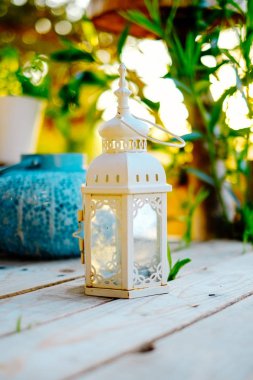 Closeup dekoratif beyaz mum fener içinde belgili tanımlık geçmiş güzel gün batımı ile ahşap tablo