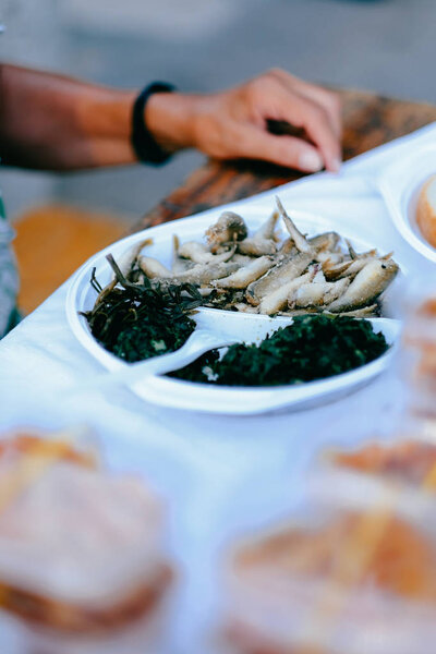 Fresh and fried sardine fish in a plate with green vegestable salad