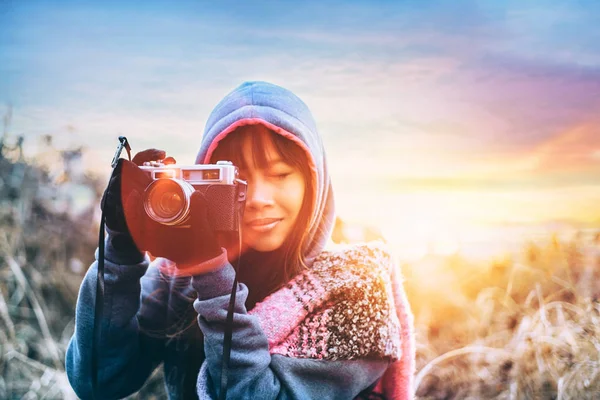 Jeune photographe par temps froid portant un pull et une écharpe colorée pendant l'après-midi coucher de soleil à l'extérieur — Photo
