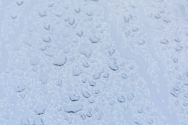 Grandes gotas de chuva em um capô de carro, a textura da tinta é azul metálico, azul abstrato bokeh fundo — Fotografia de Stock