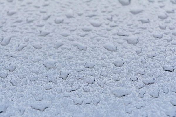 Великі краплі дощу на капоті автомобіля, текстура фарби синій метал, синій абстрактний фон боке — стокове фото