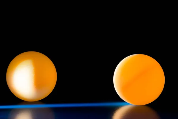 Yellow balls on a blue dark background illuminated by a side beam of light — Stock Photo, Image