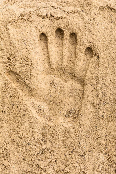 Hand print on the sand beach texture background