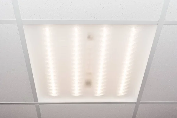 Потолок из квадратных пористых пластин и встроенная светодиодная лампа — стоковое фото