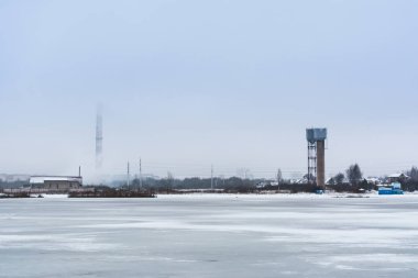 su birikintisi buza ufuk yüksek endüstriyel yapı, kasvetli bulutlu hava ile kaplıdır