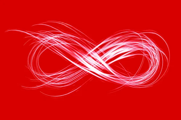 Знак бесконечности, созданный неоновым светом на красном фоне — стоковое фото
