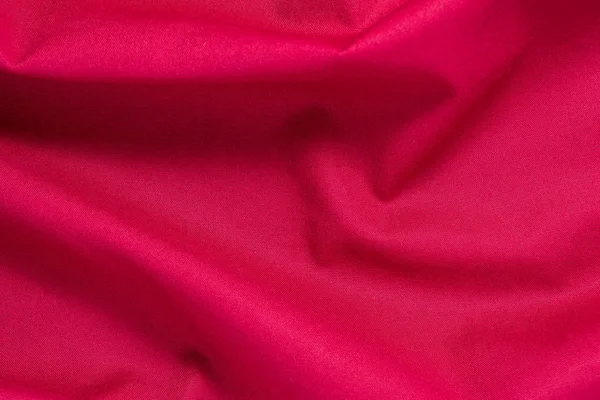 Texture of red cotton fabric with arbitrary bends and wave, abstract background — Stock Photo, Image