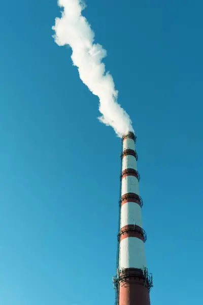 Συνδυασμένη παραγωγή θερμότητας και ενέργειας εργοστάσιο, από το σωλήνα πηγαίνει λευκό καπνό σε φόντο καθαρού ουρανού μπλε — Φωτογραφία Αρχείου