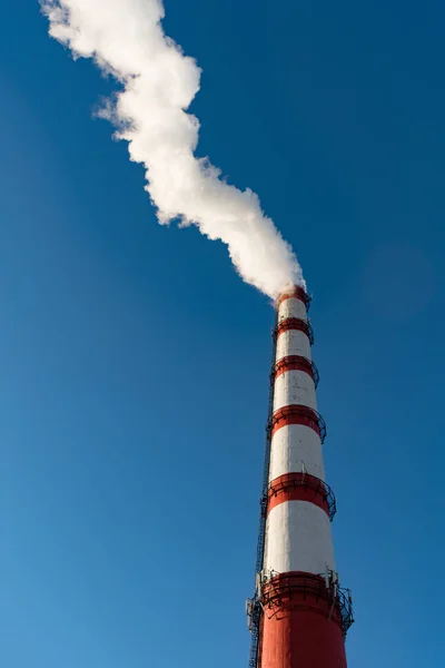 Συνδυασμένη παραγωγή θερμότητας και ενέργειας εργοστάσιο, από το σωλήνα πηγαίνει λευκό καπνό σε φόντο καθαρού ουρανού μπλε — Φωτογραφία Αρχείου