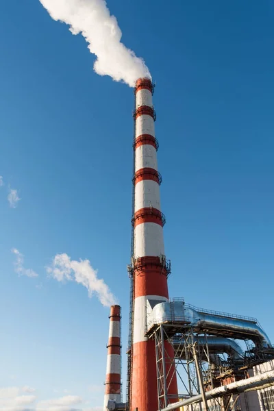 Συνδυασμένη παραγωγή θερμότητας και ενέργειας εργοστάσιο, από το σωλήνα πηγαίνει λευκό καπνό σε φόντο καθαρού ουρανού μπλε — Φωτογραφία Αρχείου