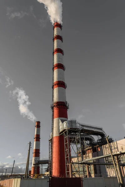 Centrale combinata di calore ed energia elettrica, dalla pipa va fumo bianco su uno sfondo di cielo blu puro — Foto Stock