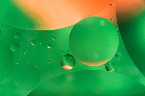 Water and oil, beautiful color abstract background based on green and orange circles and ovals, macro abstraction — Stock Photo, Image