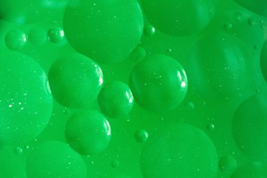 karıştırma su ve yağ, güzel renk arka plan dayalı yeşil daireler ve oval, makro soyutlama