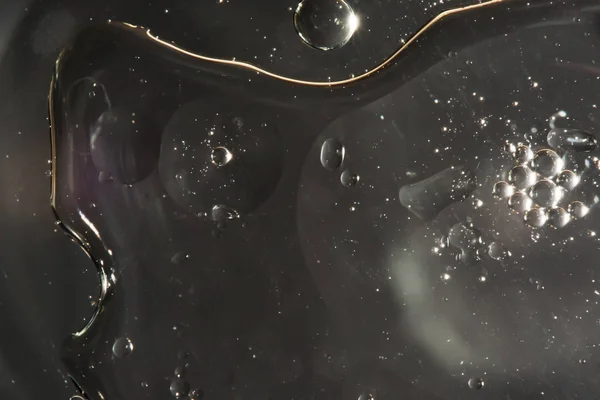 Droppar vatten på ytan av oljan, variation av olika vätskor, makro abstrakt bakgrund — Stockfoto