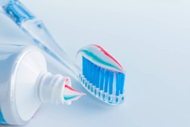 Mavi kıllar ile net plastik diş fırçası, bir tüp dışında beyaz mavi kırmızı diş macunu sıkar