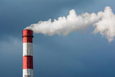 Mavi gökyüzünde tüten bir baca. Zararlı gazların atmosfere yayılması, sera etkisi. Hava kirliliği, büyük bir sigara piposuna yakın çekim.