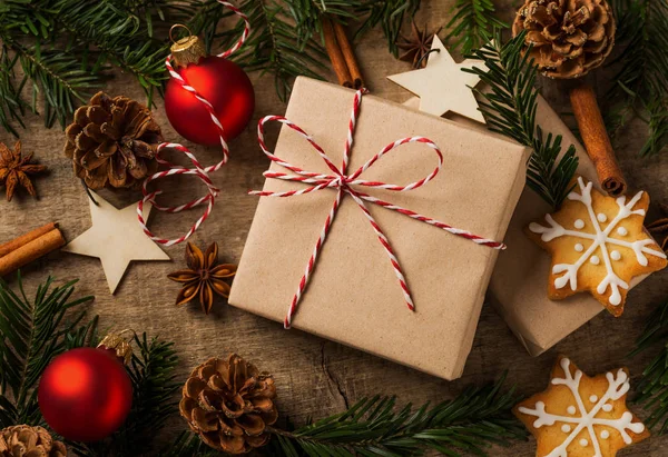 Kerstcadeau verpakt in kraftpapier met natuurlijke decoratie — Stockfoto