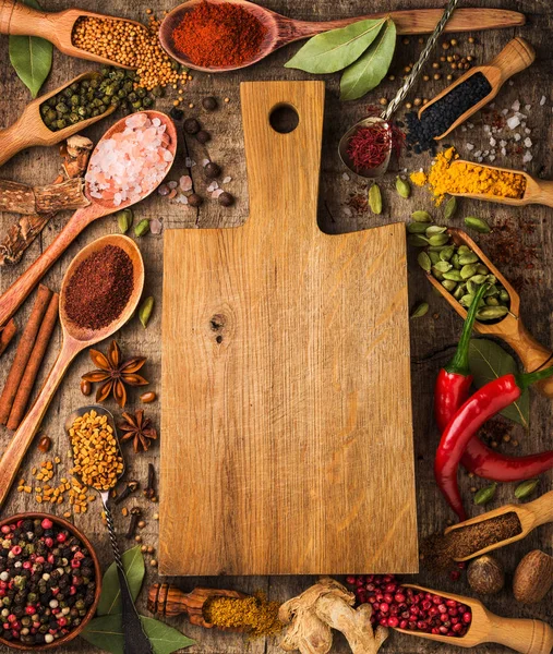 Background with different spices around the cutting board — Stock Photo, Image