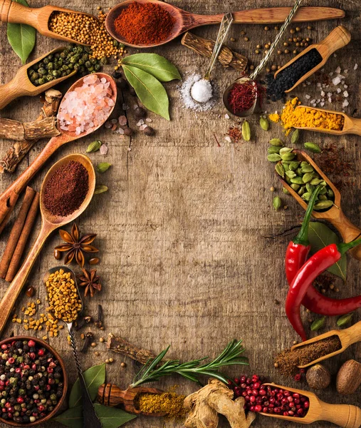 Herbs and spices on rough wood — Stock Photo, Image