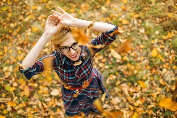Giovane ragazza ballando sotto le foglie che cadono nella sosta di autunno — Foto Stock
