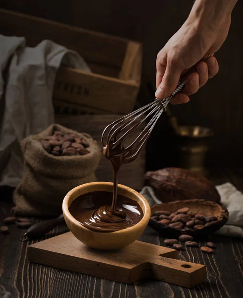 Dark still life with melted chocolate in wooden bowl — Stock Photo, Image