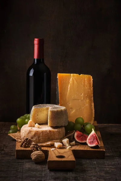 奶酪板、 水果和葡萄酒在粗糙的木头上 — 图库照片