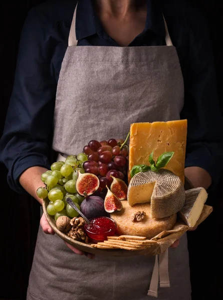 Γυναίκα που κρατά ένα πιάτο τυρί με φρούτα και μαρμελάδες — Φωτογραφία Αρχείου