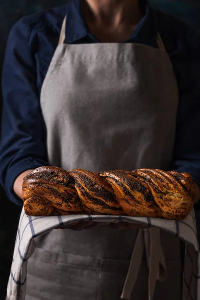 Donna che tiene in casa torta di semi di papavero — Foto Stock