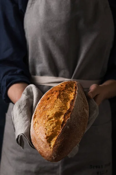 Baker holding fresh homemade bread — Stok Foto