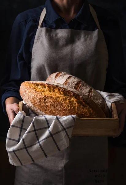 Baker holding fresh homemade bread — Stok Foto