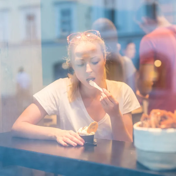 Joven bonita mujer comiendo helado en gelateria . — Foto de Stock