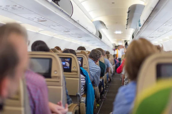 Wnętrze samolotu z pasażerów na siedzeniach czeka na taik off. — Zdjęcie stockowe