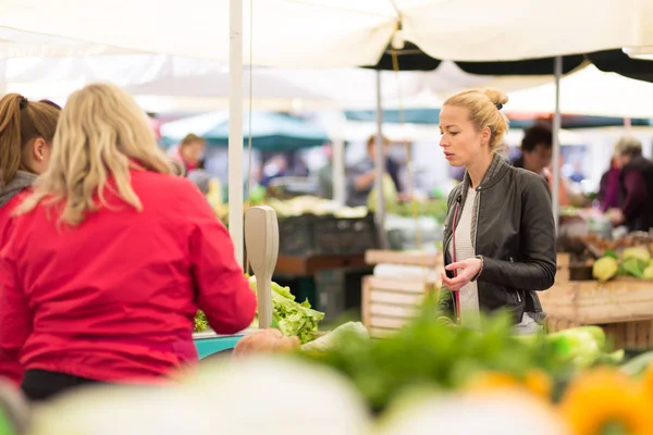 Vrouw koopt groente op de lokale voedselmarkt. — Stockfoto