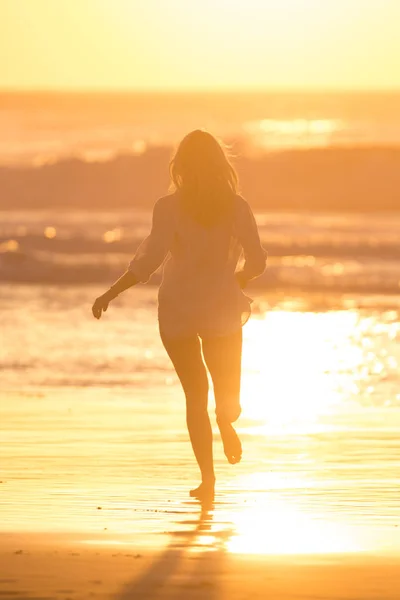 Woman running on the beach in sunset. — Stock Photo, Image