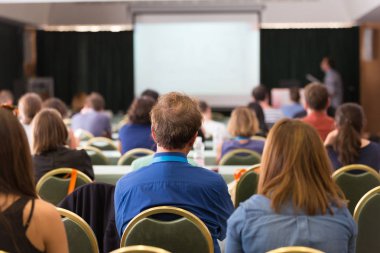 Konferans salonunda iş konferansına katılan seyirciler.