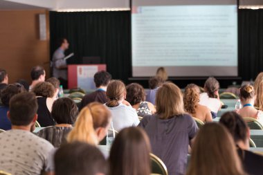 Konferans salonunda iş konferansına katılan seyirciler.