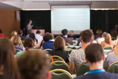 Konferans salonunda iş konferansına katılan seyirciler.