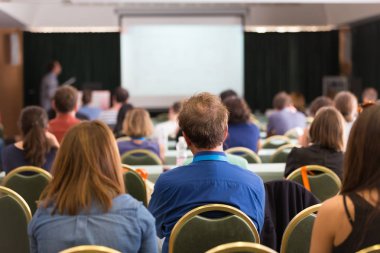Konferans salonunda iş konferansına katılan seyirciler.